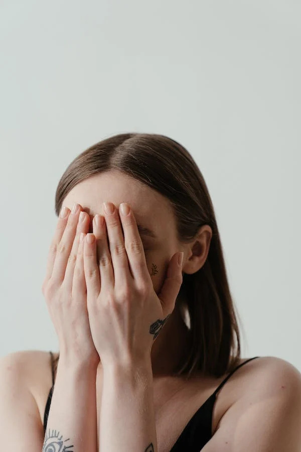 girl hiding behind her hands