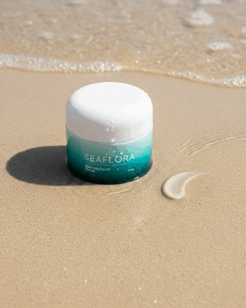 Refining Facial Polish jar on a pristine beach with gentle waves, representing its stress-free renewal for radiant skin, complementing holistic gut health.